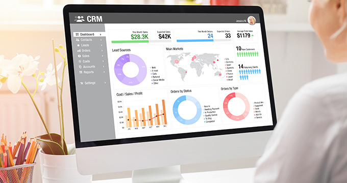 a woman looking at a CRM management system